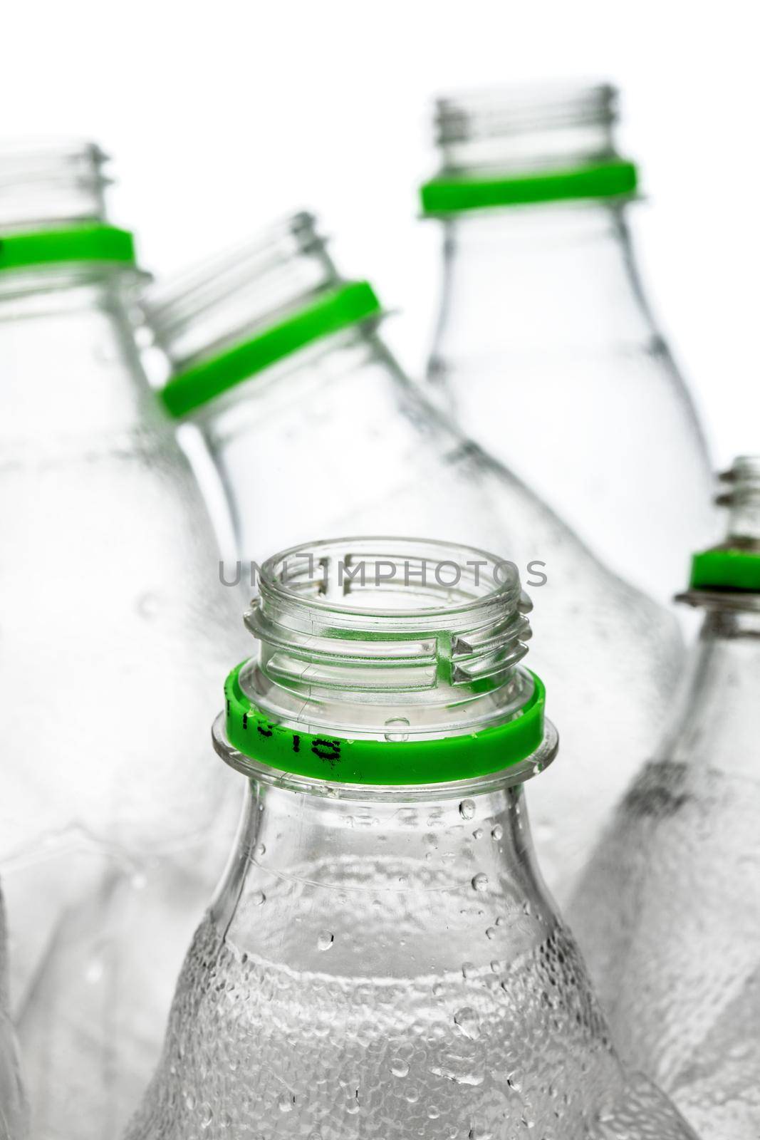 group of smashed empty plastic bottles with green caps, isolated on white background