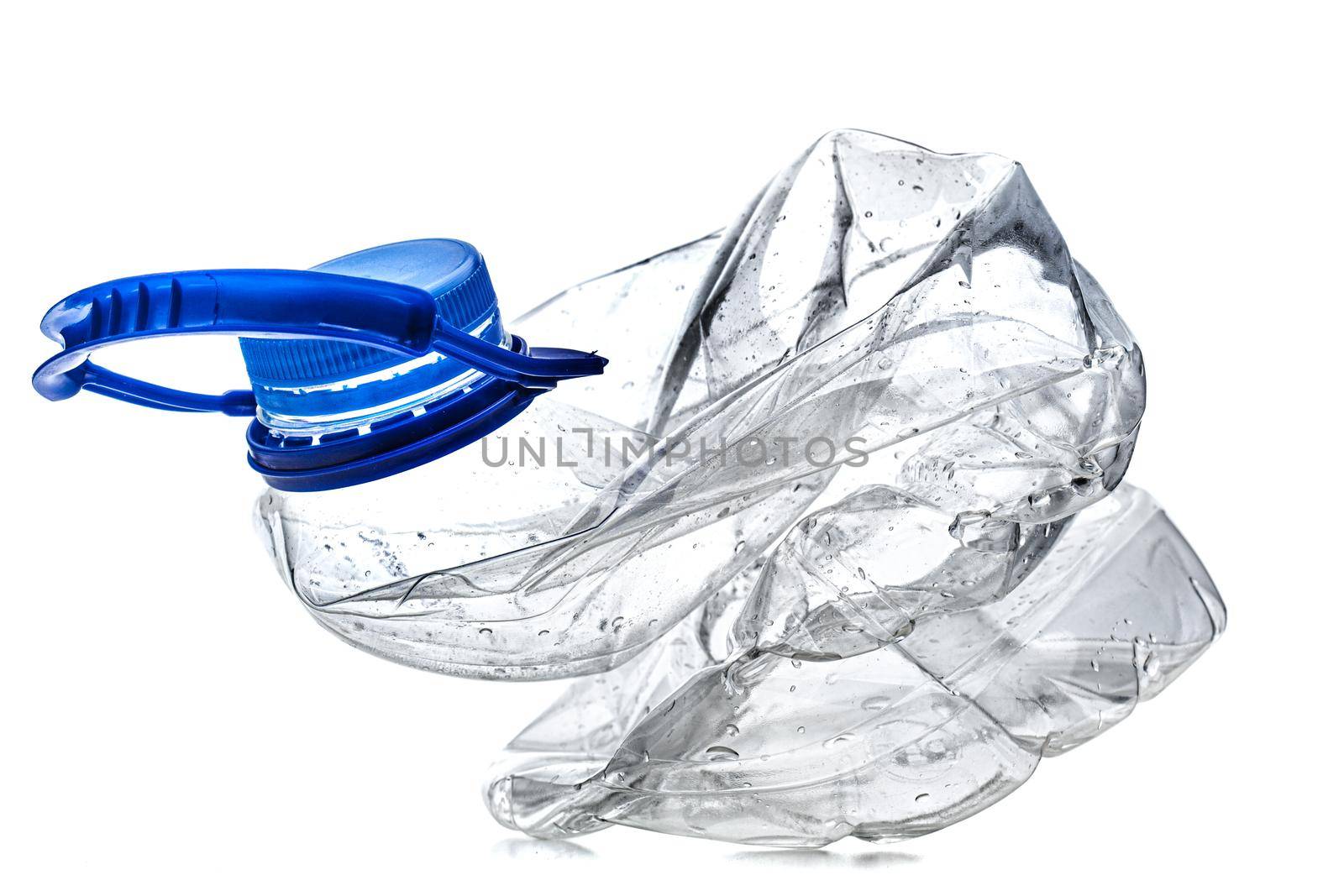 smashed empty plastic bottle with blue cap, isolated on white background