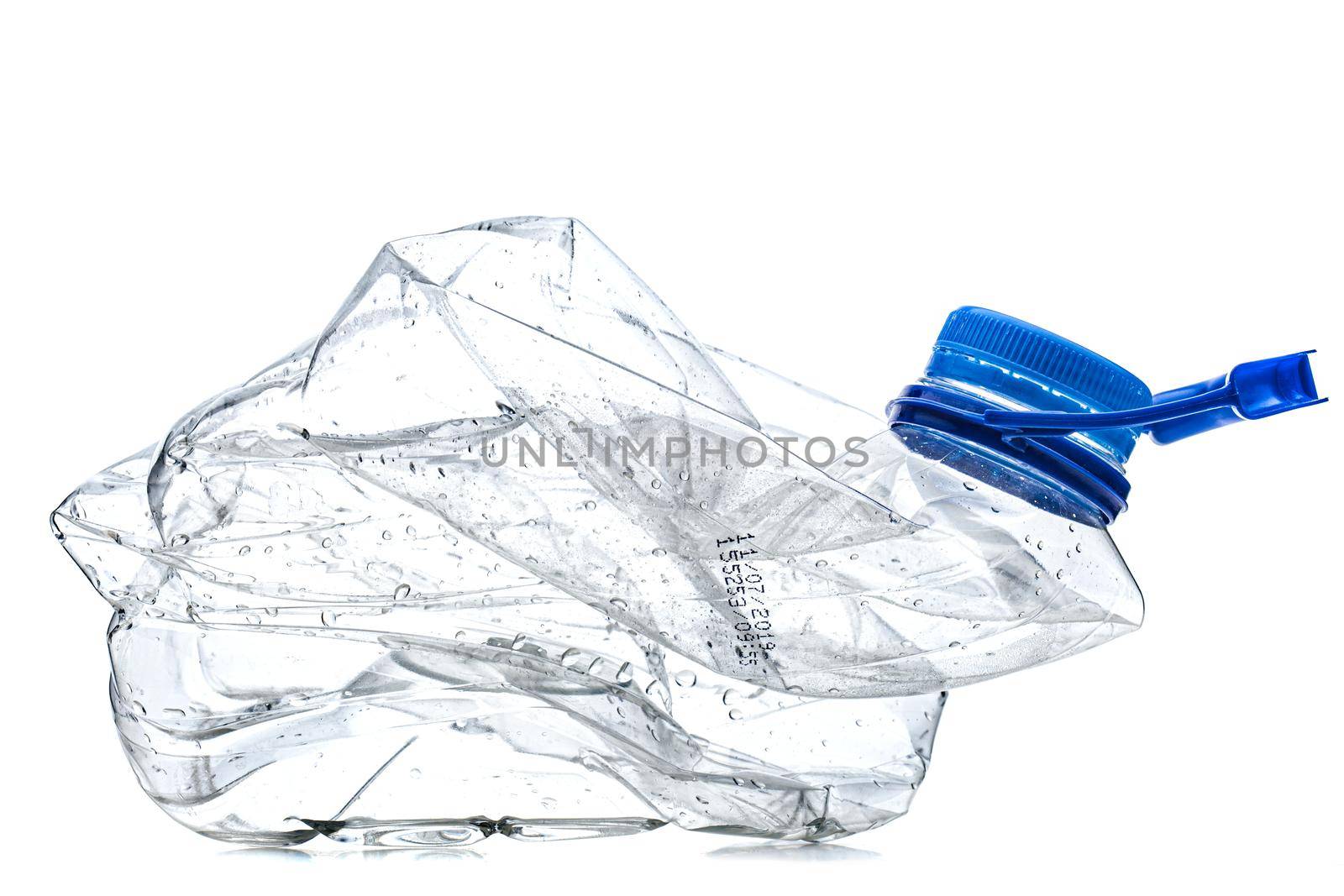 smashed empty plastic bottle with blue cap, isolated on white background. by kokimk