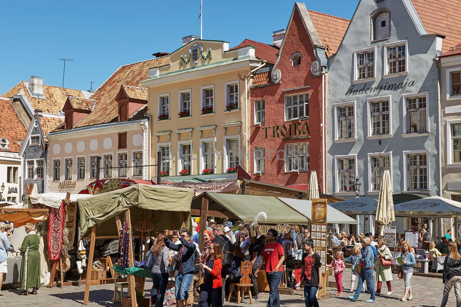 TALLINN, ESTONIA - JULY 07, 2017: Tourists crowd enjoying shopping at the medieval Town Square in the walled city of Tallinn Estonia