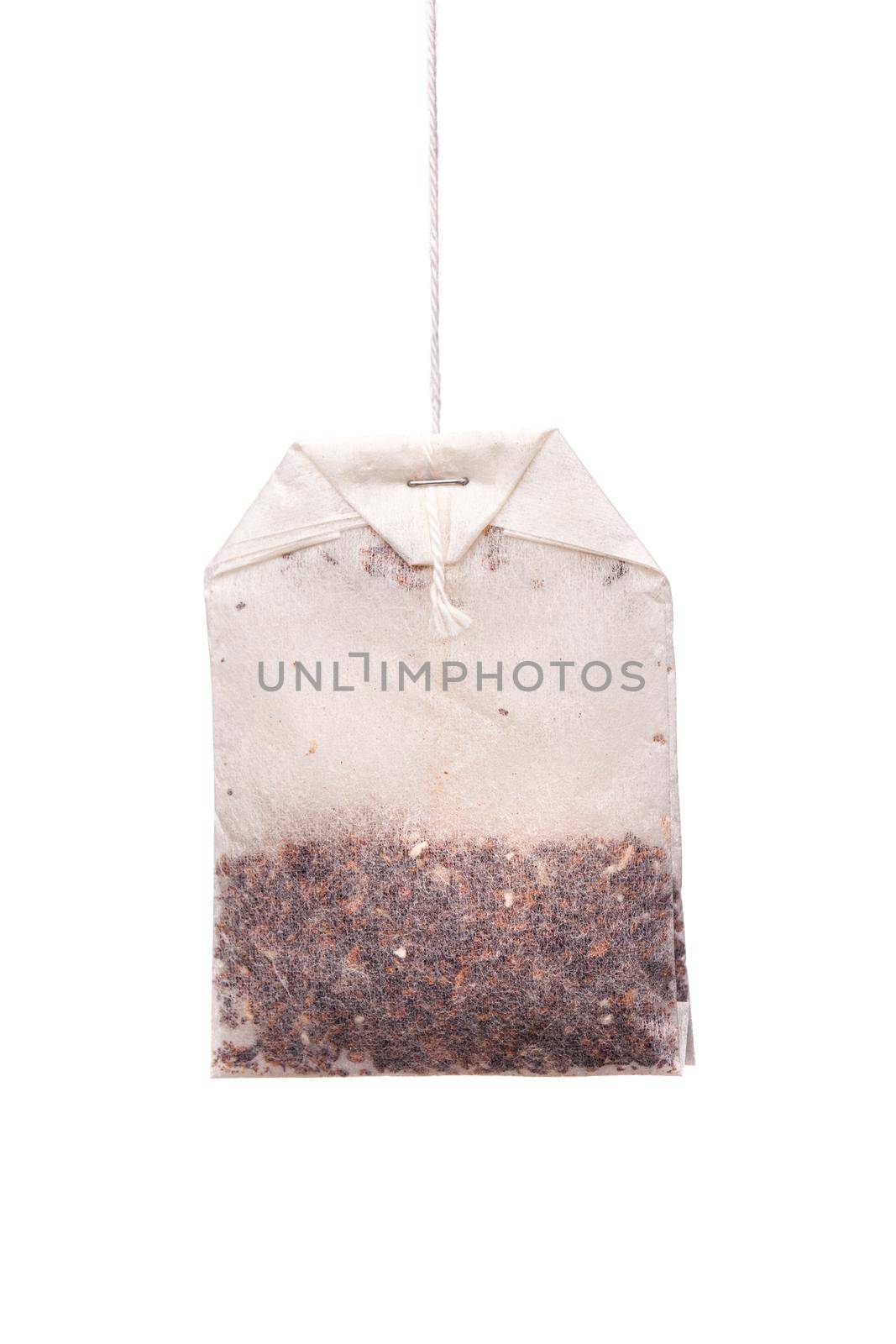 Herbal tea in paper bag. Teabag hanging against white background by kokimk