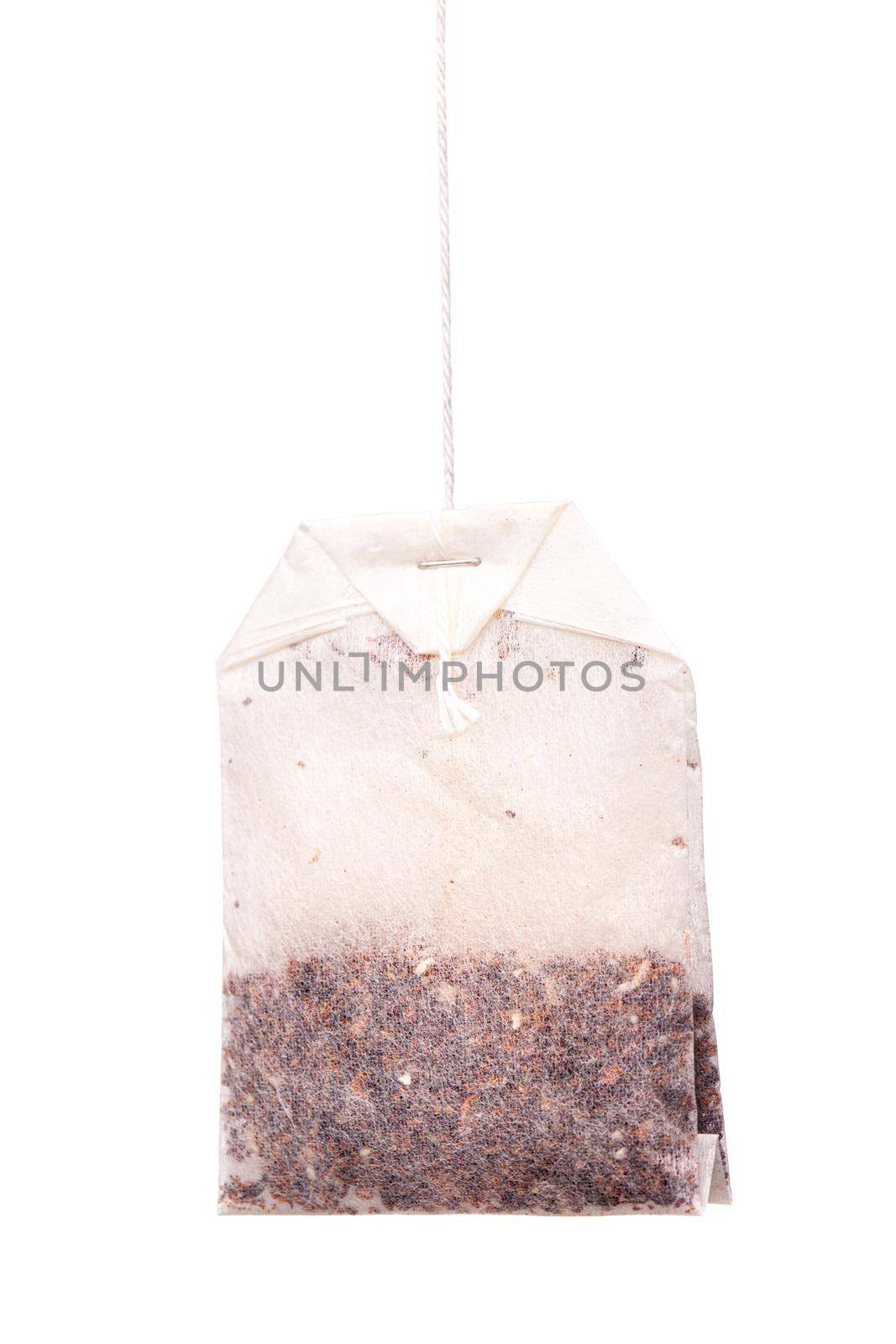 Herbal tea in paper bag. Teabag hanging against white background by kokimk