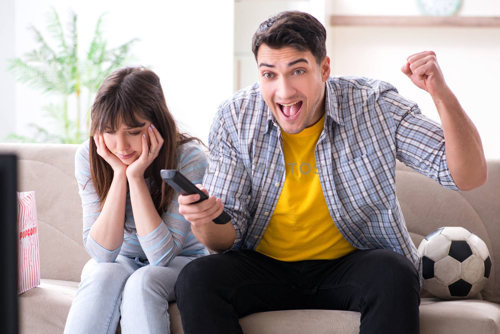 Family pair watching football at home