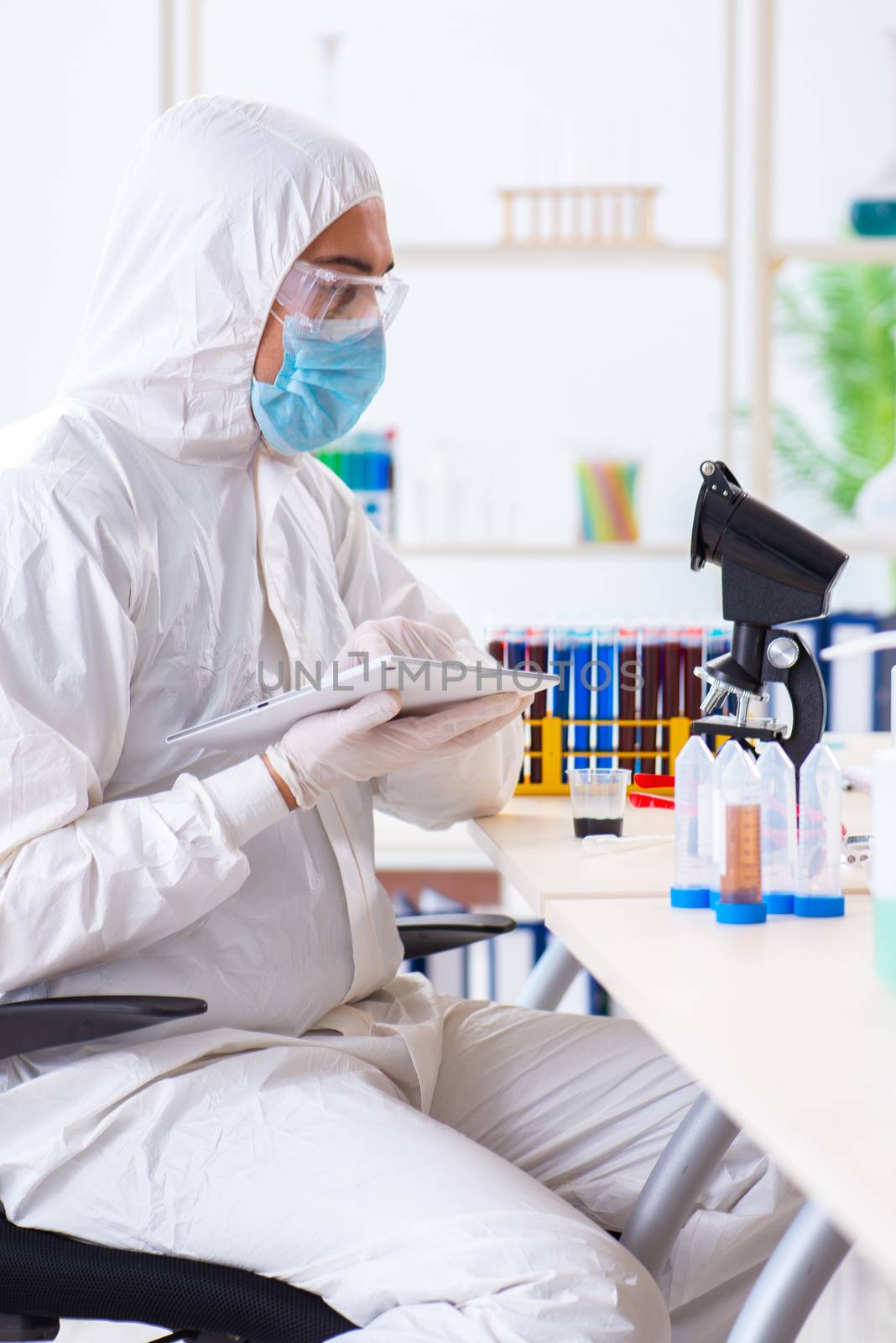 Young chemist student working in lab on chemicals