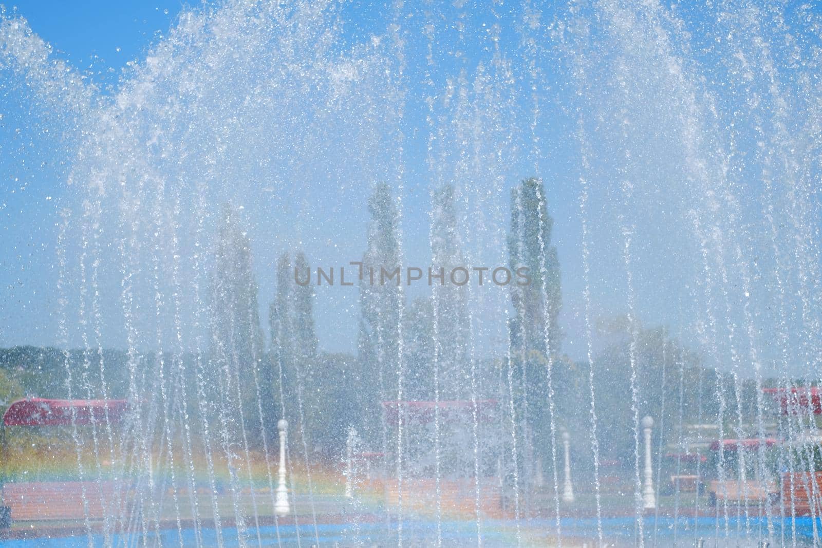 artesian fountain on blue sky with rainbow