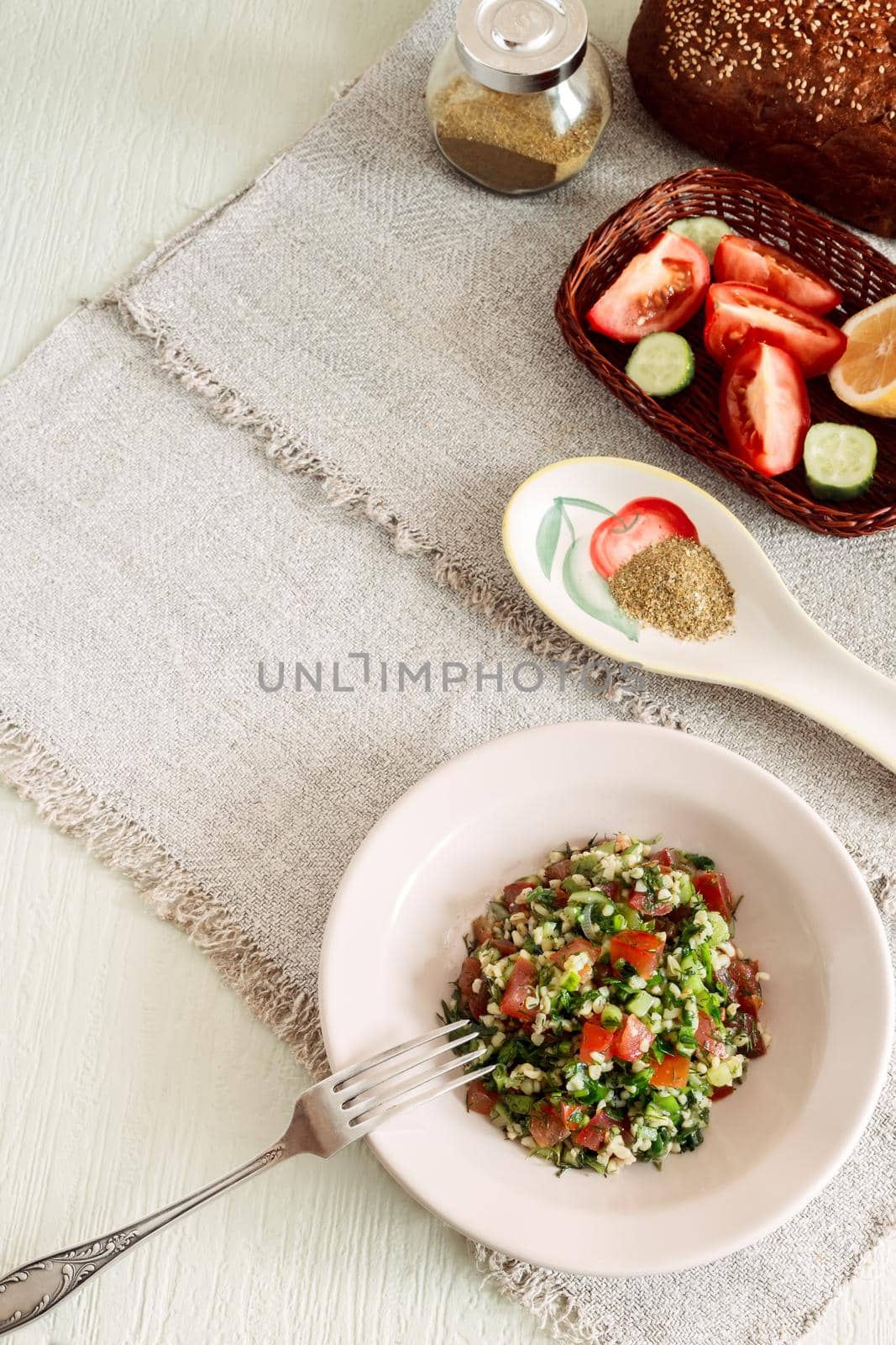 Light and tasty salad of middle Eastern cuisine Tabule , prepared from vegetables, herbs , bulgur cereals, seasoned with lemon juice and olive oil.