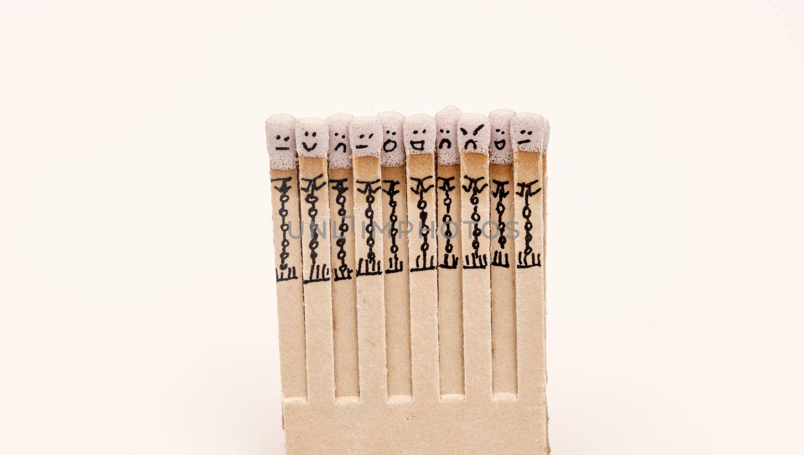 matchsticks with faces painted on the heads on white on white