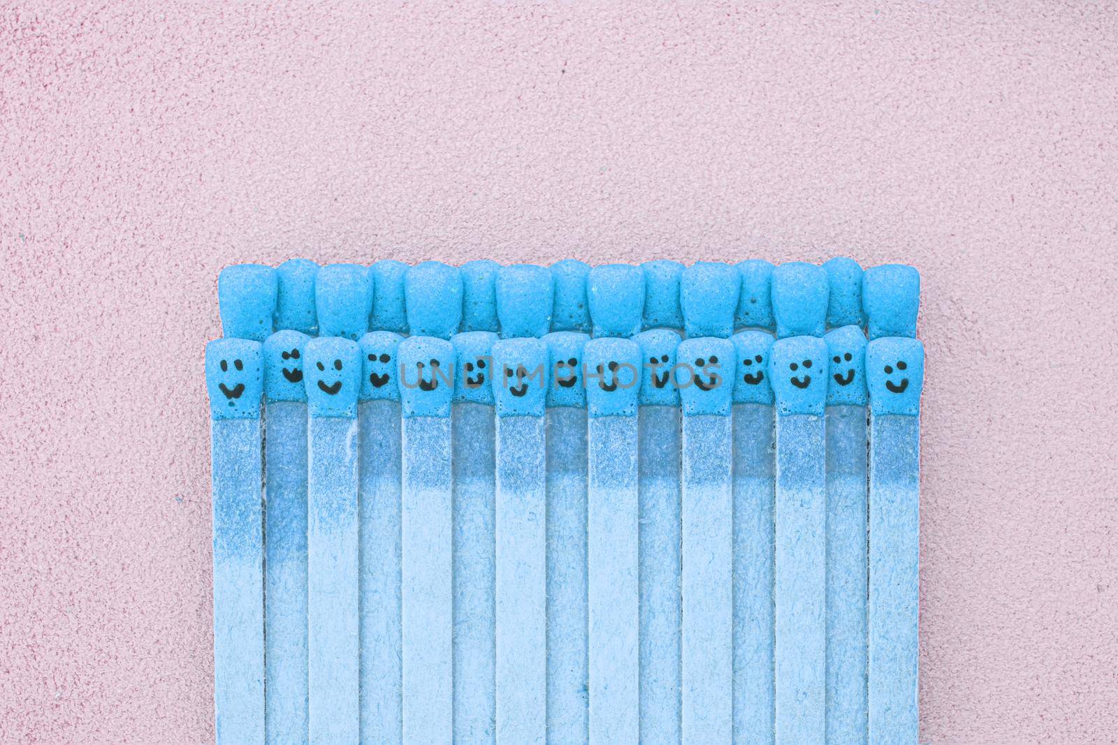 matchsticks with faces painted on the heads with natural leather background by Roberto