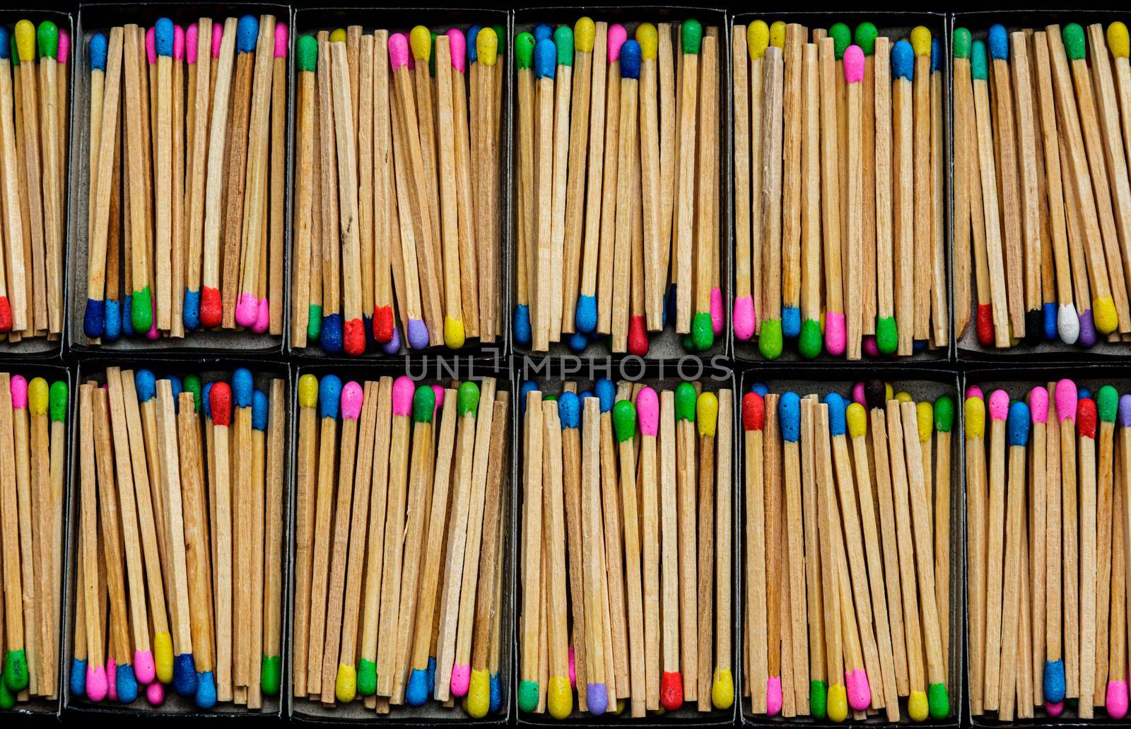 multicolored match sticks in boxes on a black background by Roberto