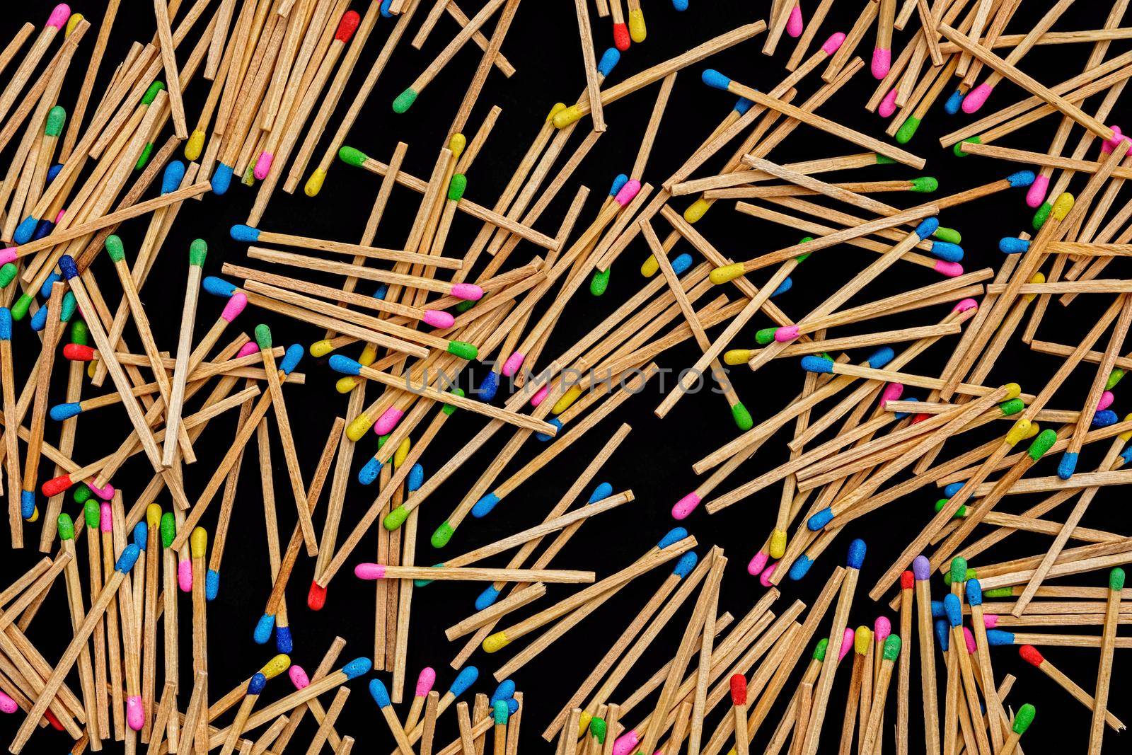 multicolored match sticks on a black background by Roberto