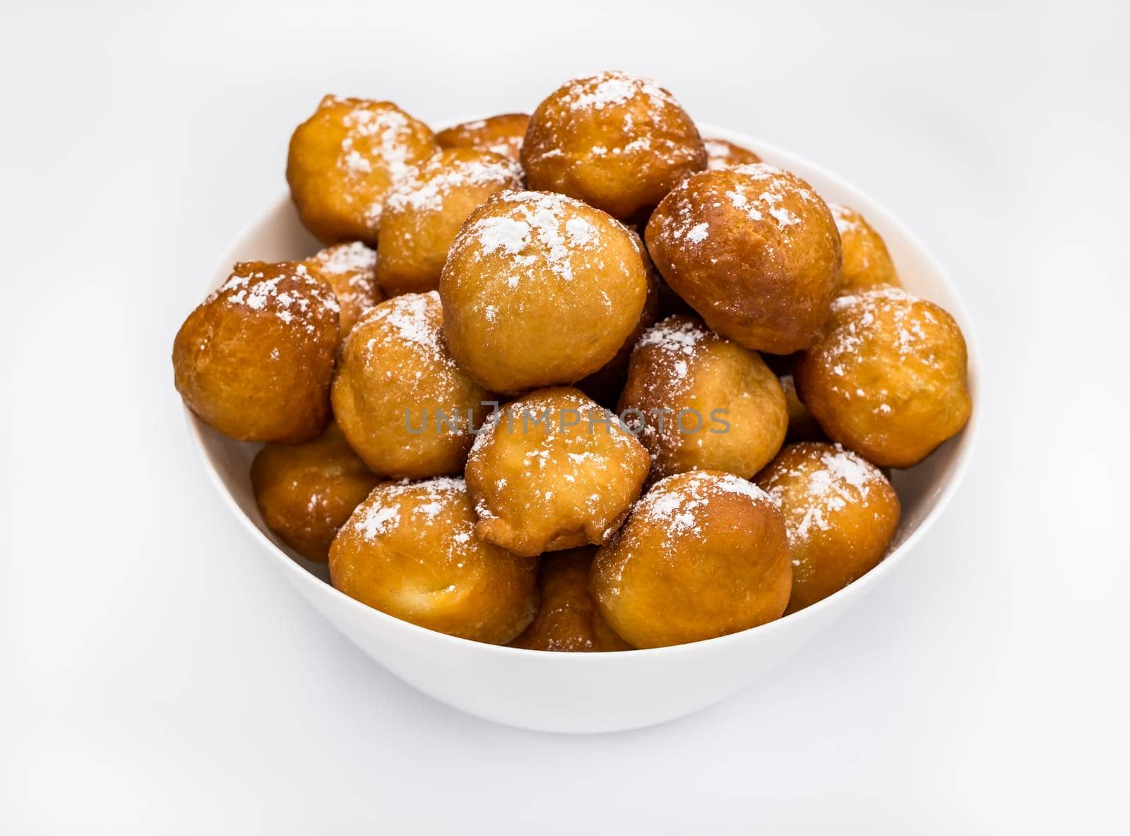 sweet donuts laid out pyramid sprinkled with powdered sugar on the plate