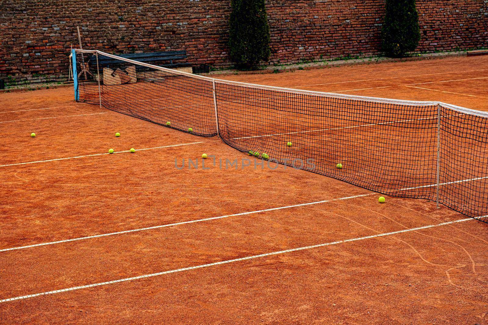 tennis balls on the clay court by Roberto