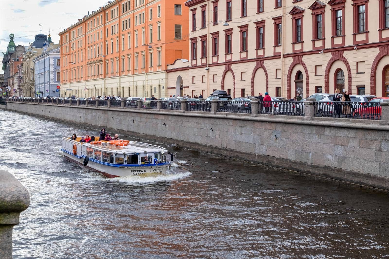 A pleasure boat sails along the Griboyedov Canal past historic buildings by OlgaGubskaya