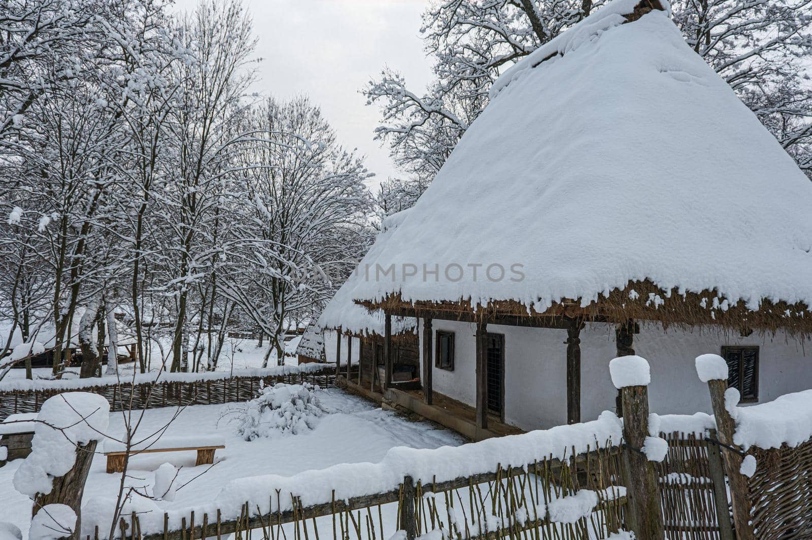 Traditional Romanian village with old house straw roofing covered with snow