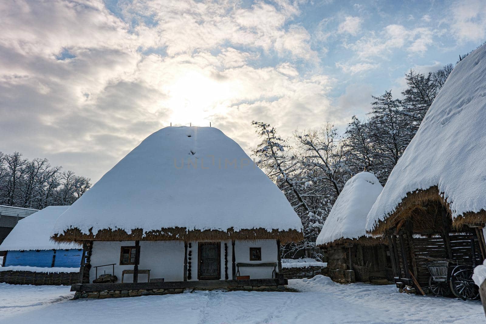 Traditional Romanian village with old house straw roofing covered with snow