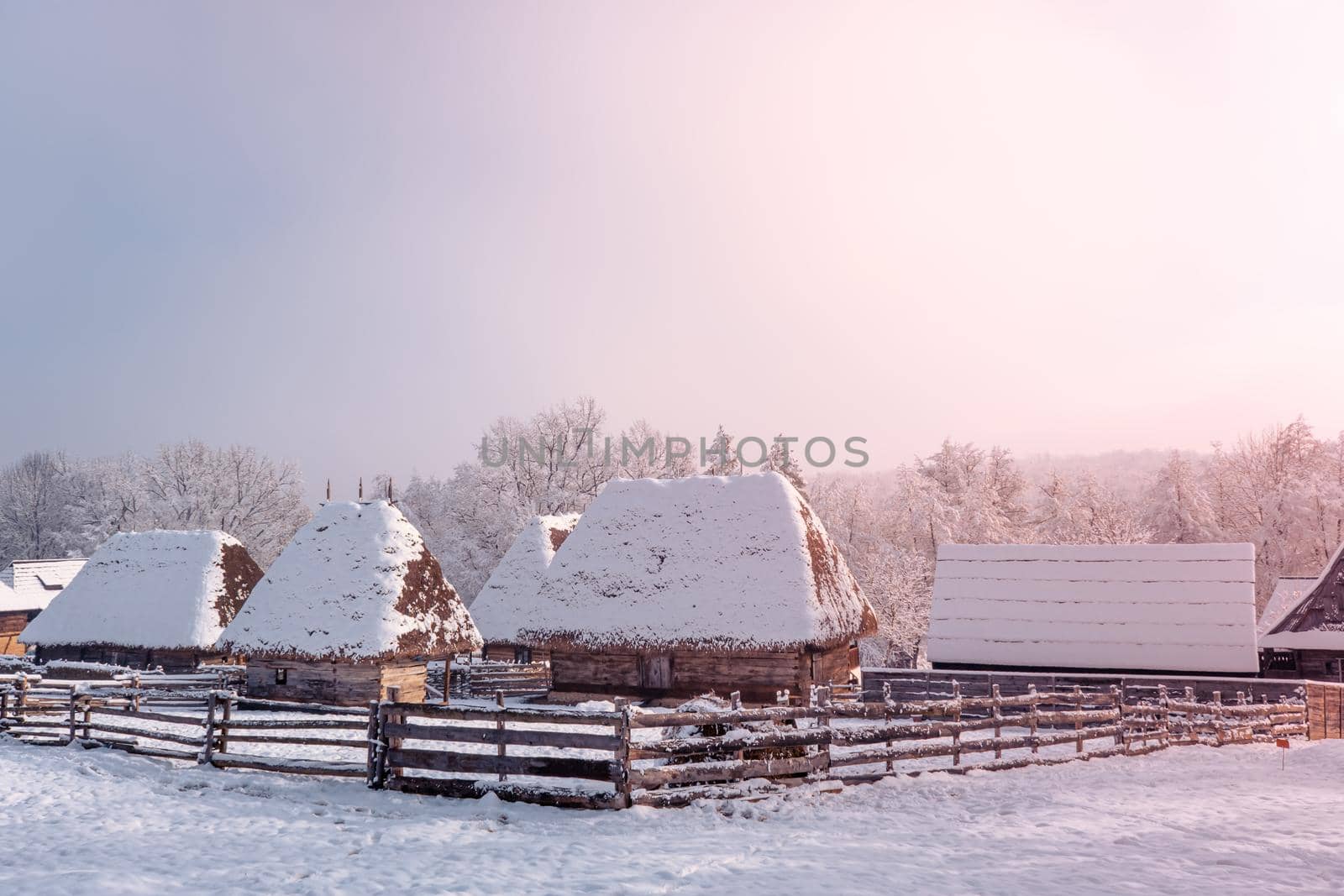 Traditional Romanian village in Transylvania with old house straw roofing covered with snow in a cold day