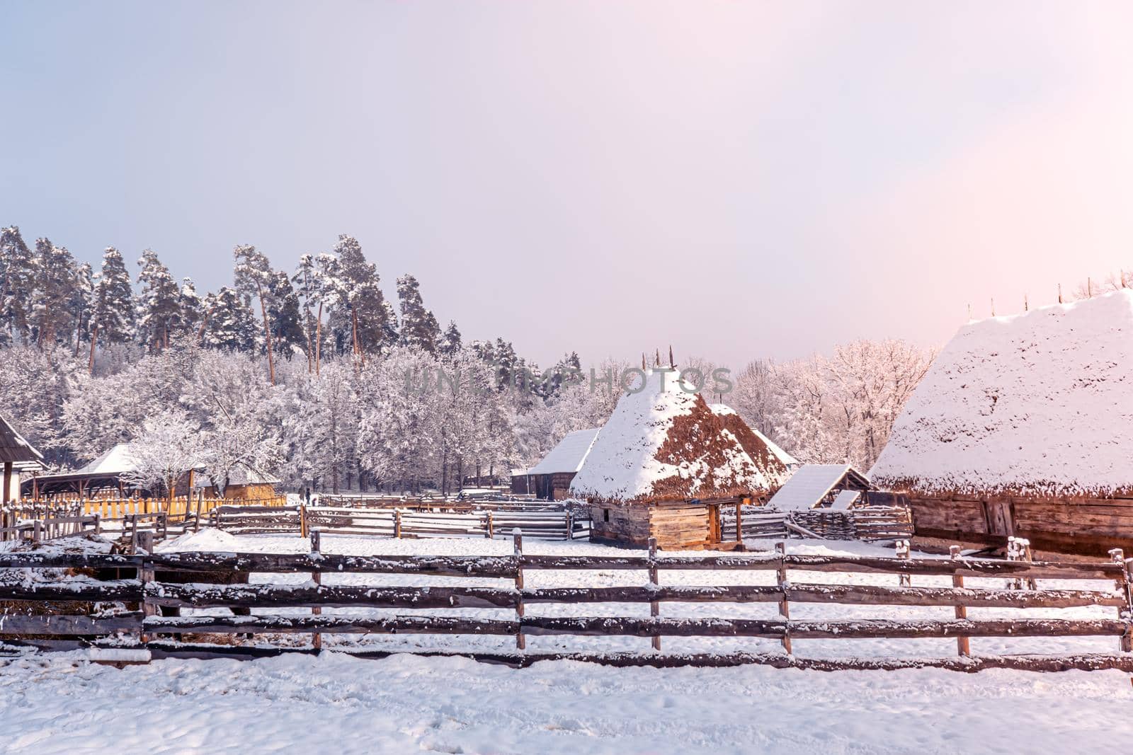 Traditional Romanian village in Transylvania with old house straw roofing covered with snow in a cold day