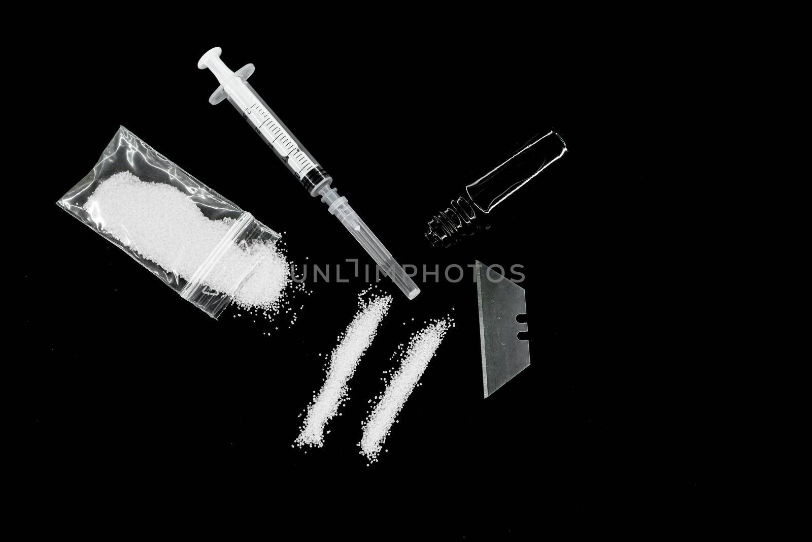 white drugs line with syringe, broken ampoule on black background