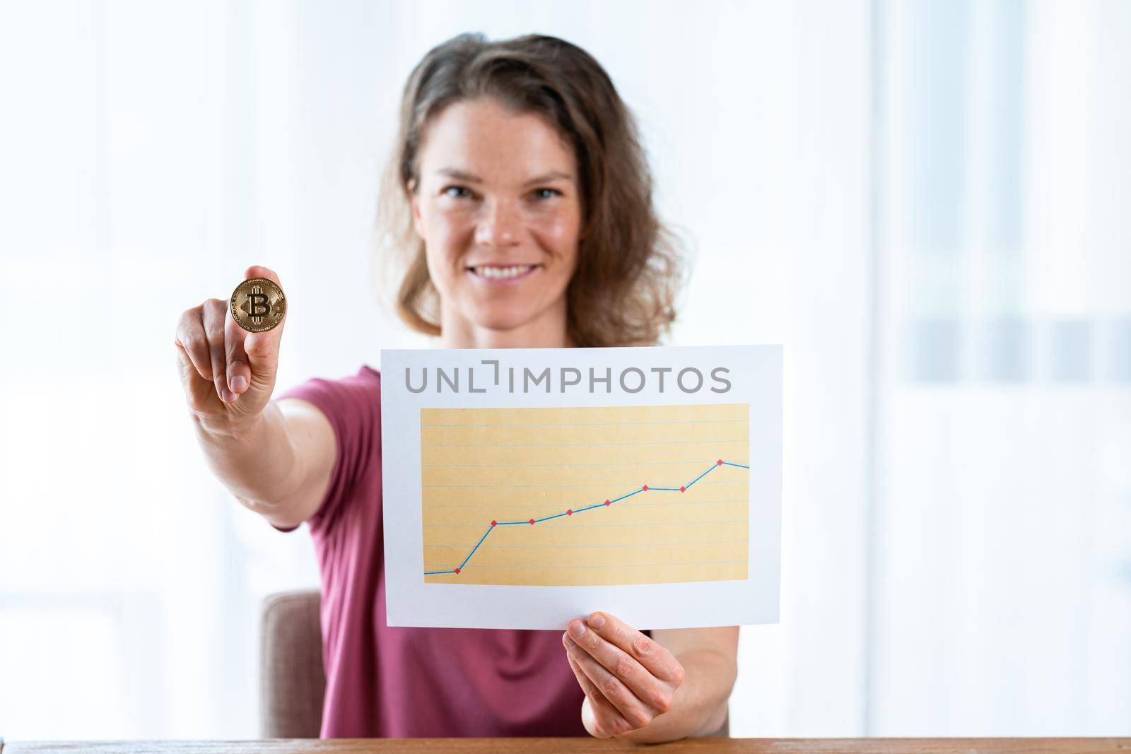 bitcoin coin in the hand of a young attractive business woman by Edophoto