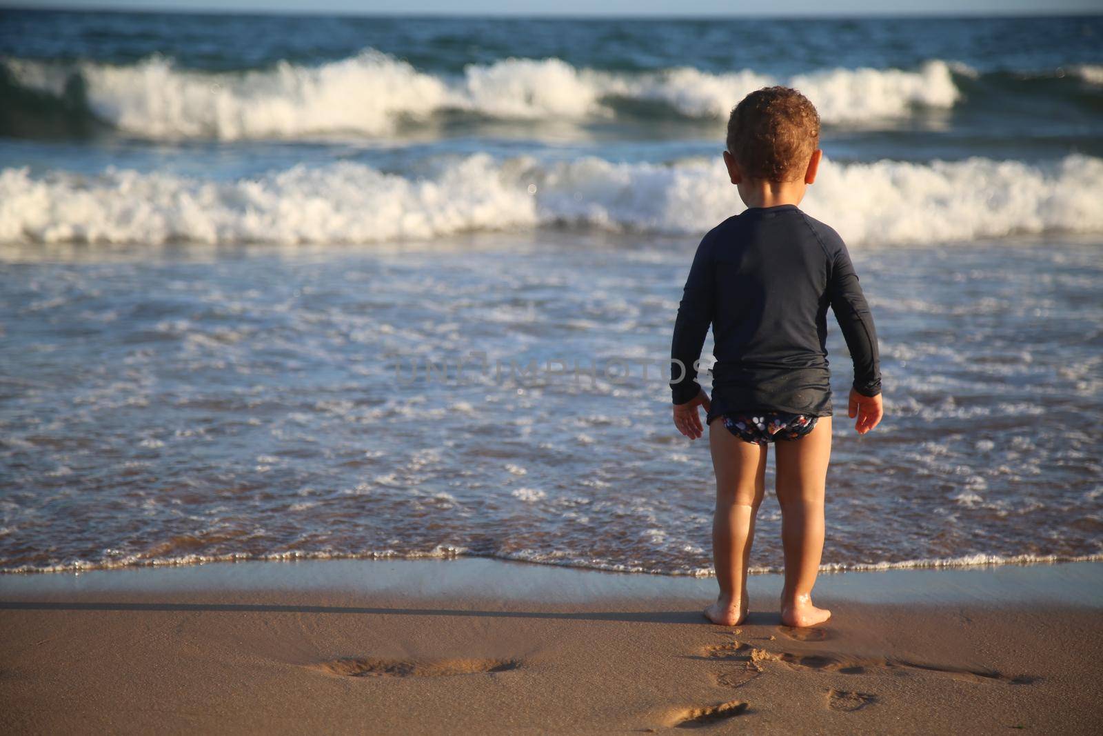 child plays on the beach by joasouza