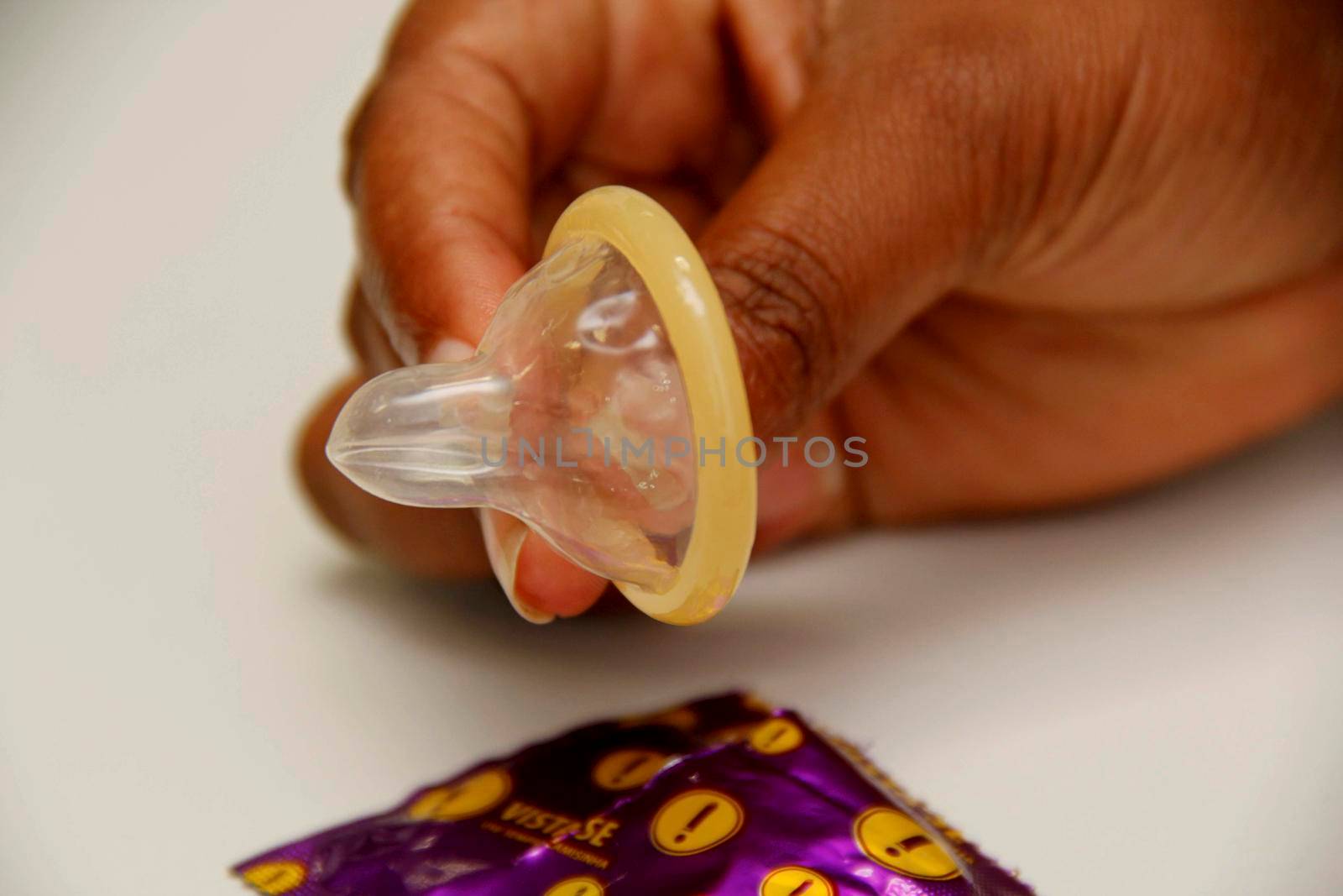 salvador, bahia / brazil - february 6, 2013: hand holds male condom, contraceptive method and also used to control sexually transmitted diseases.
