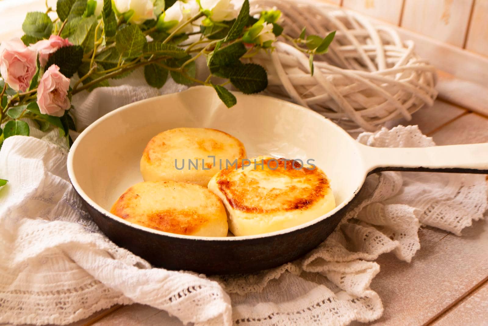 Cottage cheese pancakes in a white pan on a white shabby table