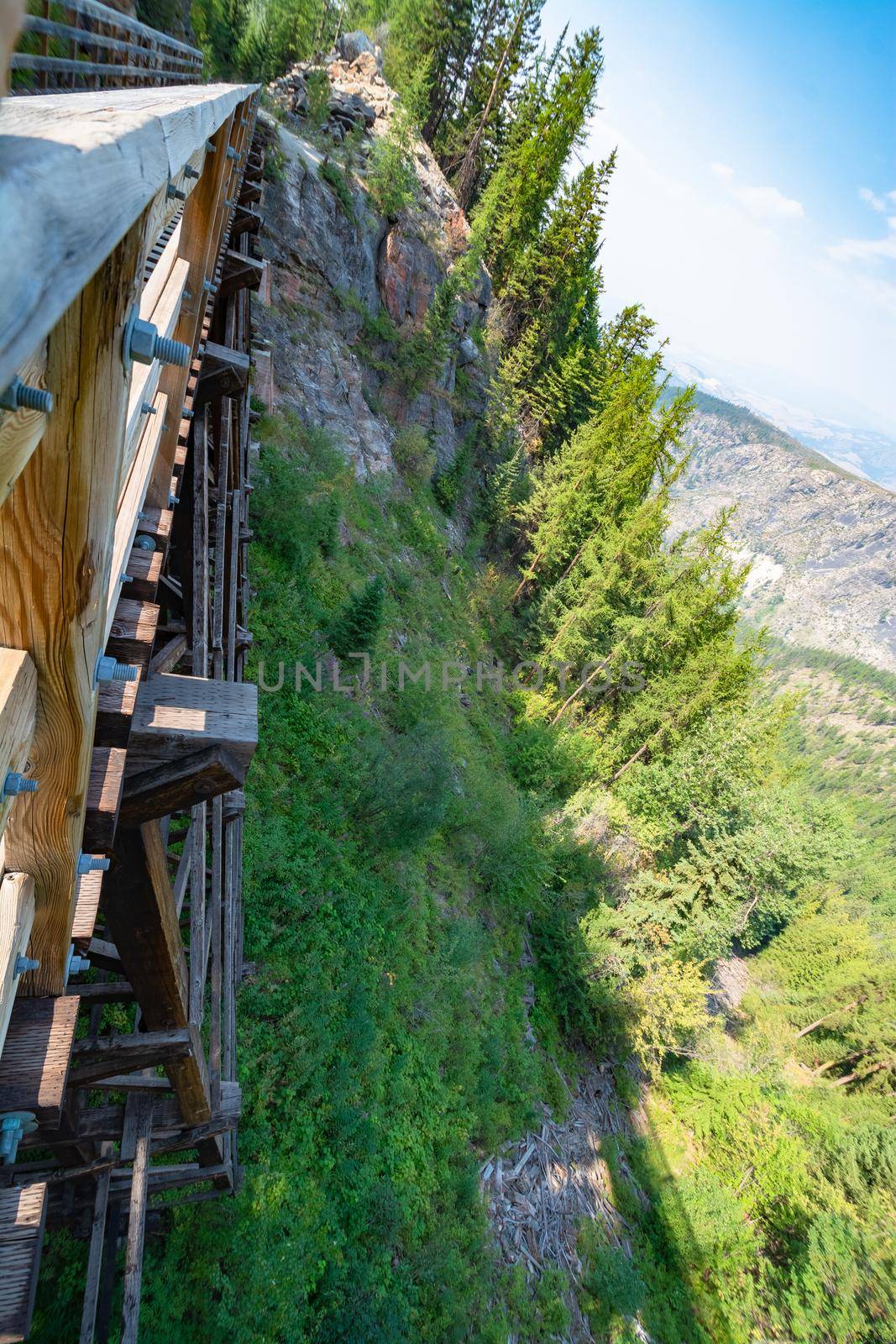 Dizzying look from the bridge to mountain rocky profile with steep slope down to the bottom of Myra canyon