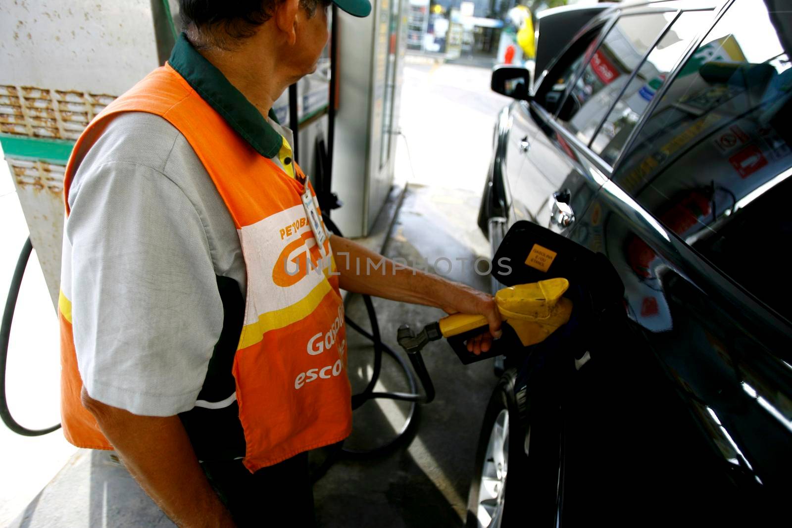 salvador, bahia / brazil - october 8, 2014: gas station attendant is seen filling up a vehicle at petrol stations in the Petrobras network, in the city of Salvador.