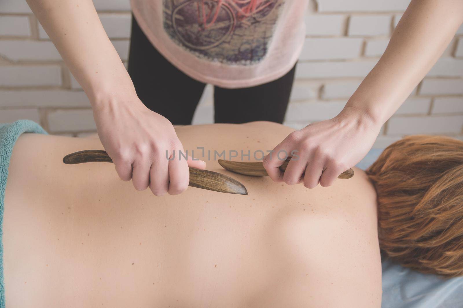 therapeutic back massage in the spa salon makes the girl a massage by ozornina