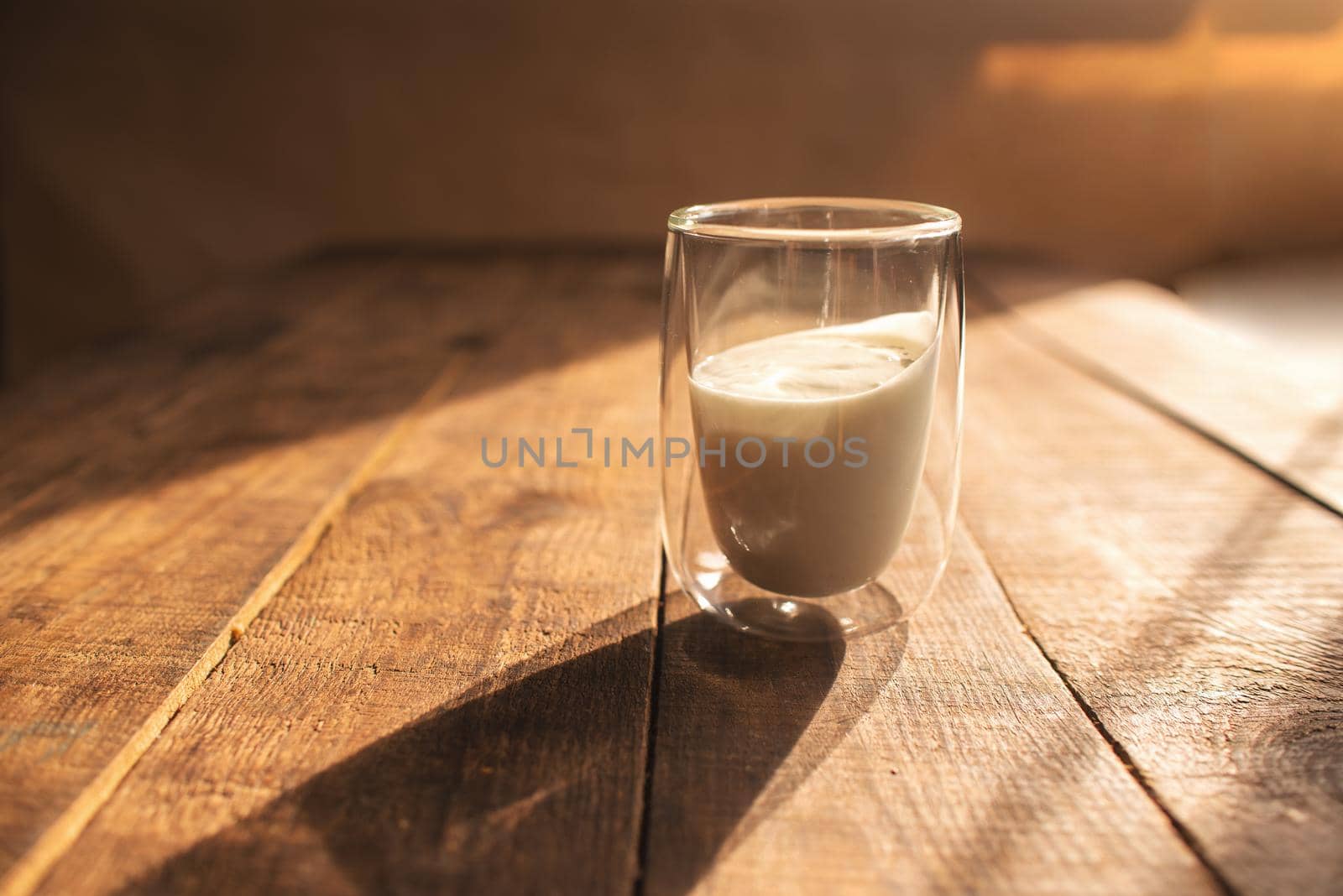 double glass with yogurt on a wooden table by ozornina