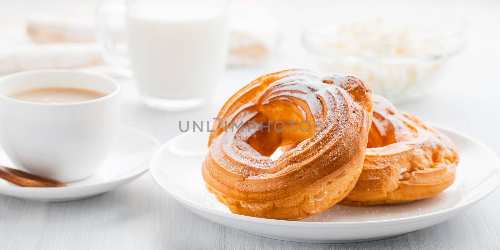Morning coffee with cake. Custard rings, coffee, cream, cottage cheese on a white wooden table by galsand