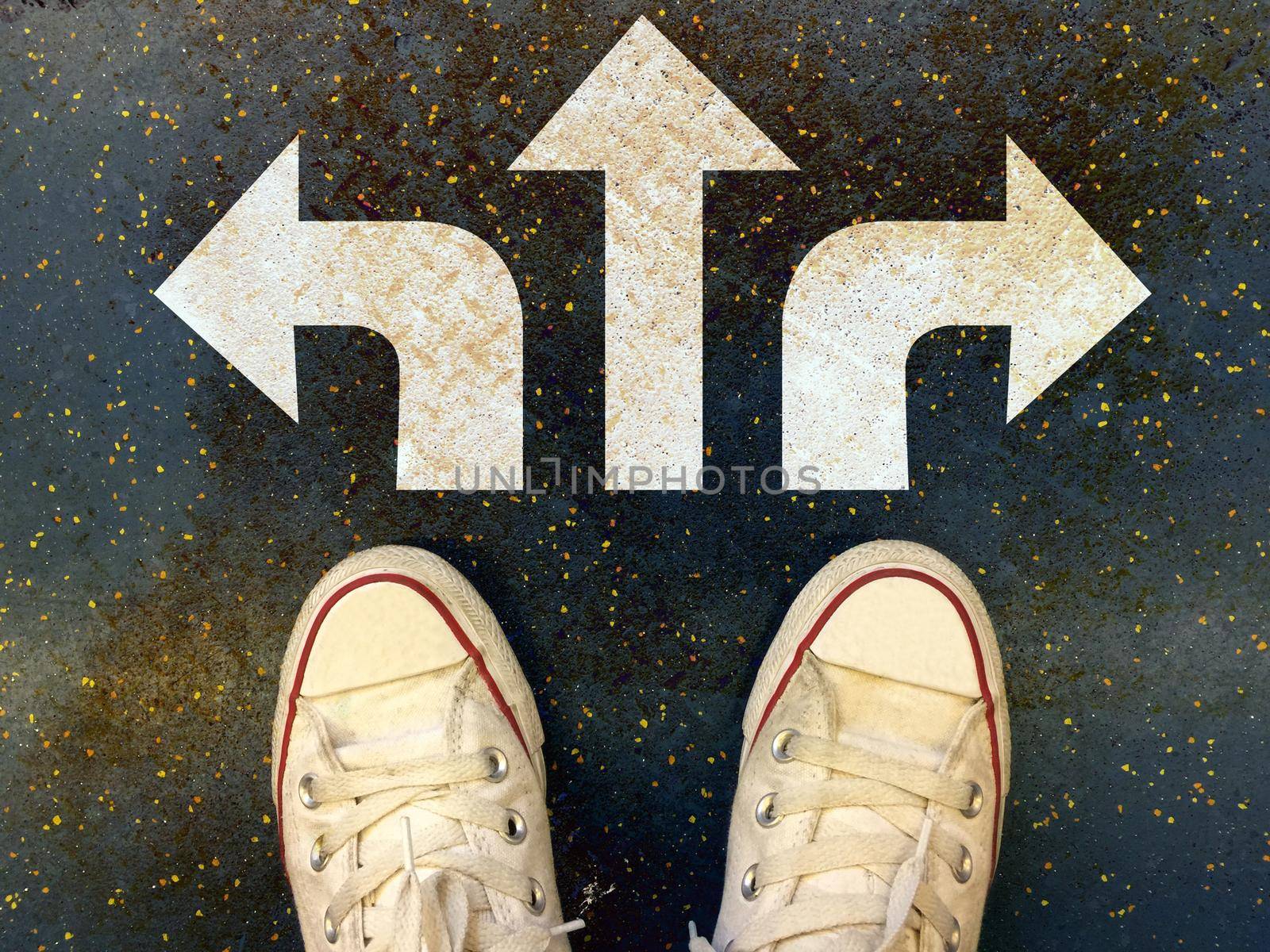 Sneakers shoes with three white arrows print pointing on grunge road , making decision business concept by Yoopho