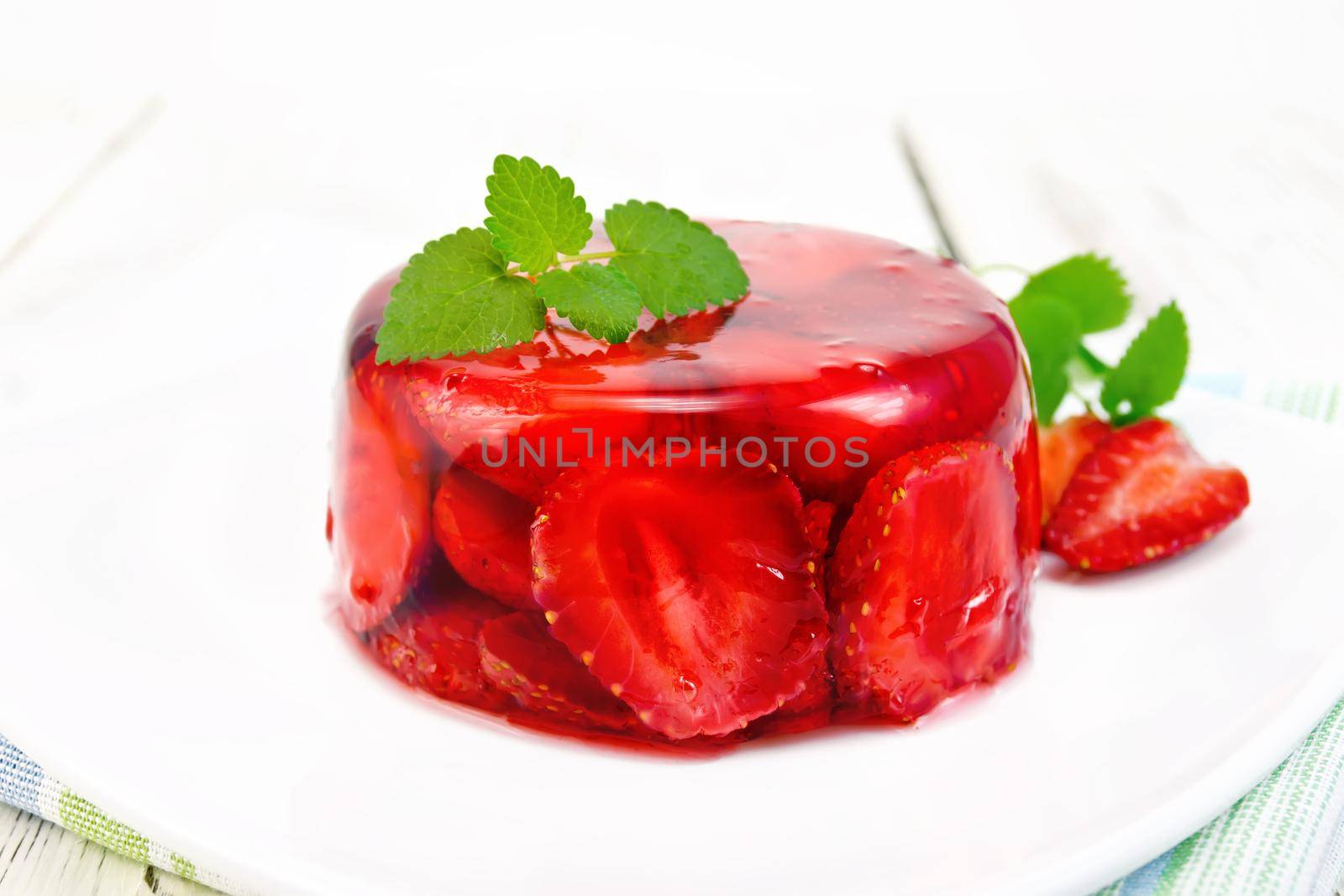 Jelly strawberry with mint in plate on board by rezkrr