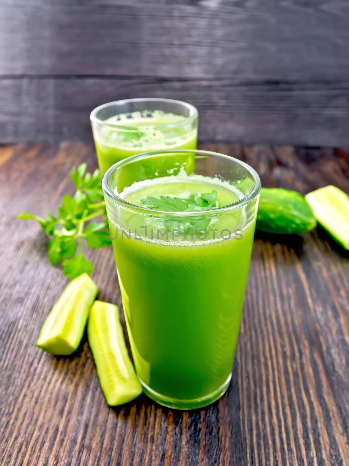 Juice cucumber with parsley in two glass on board by rezkrr