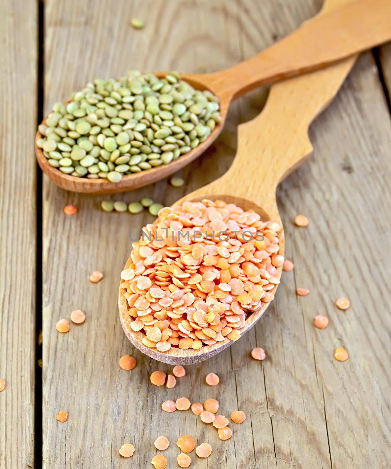 Lentils red and green in spoon on wooden board by rezkrr