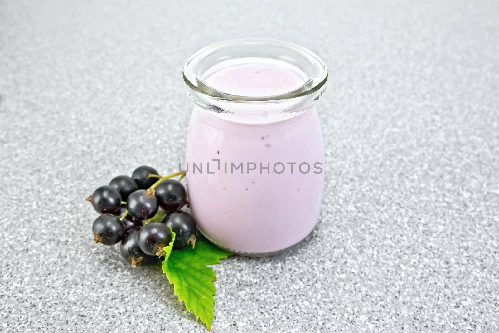 Milk cocktail with black currant in jar on granite table by rezkrr