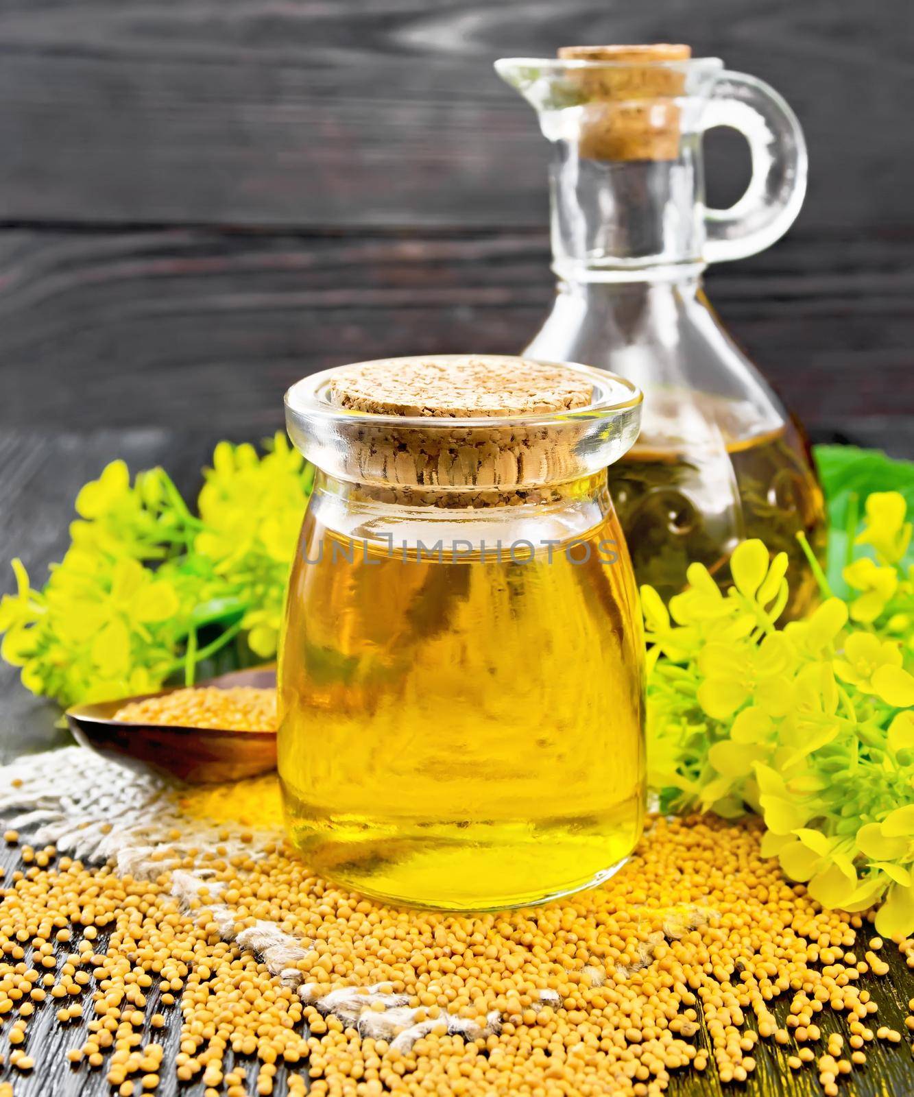 Oil mustard in jar and decanter with flower on burlap by rezkrr