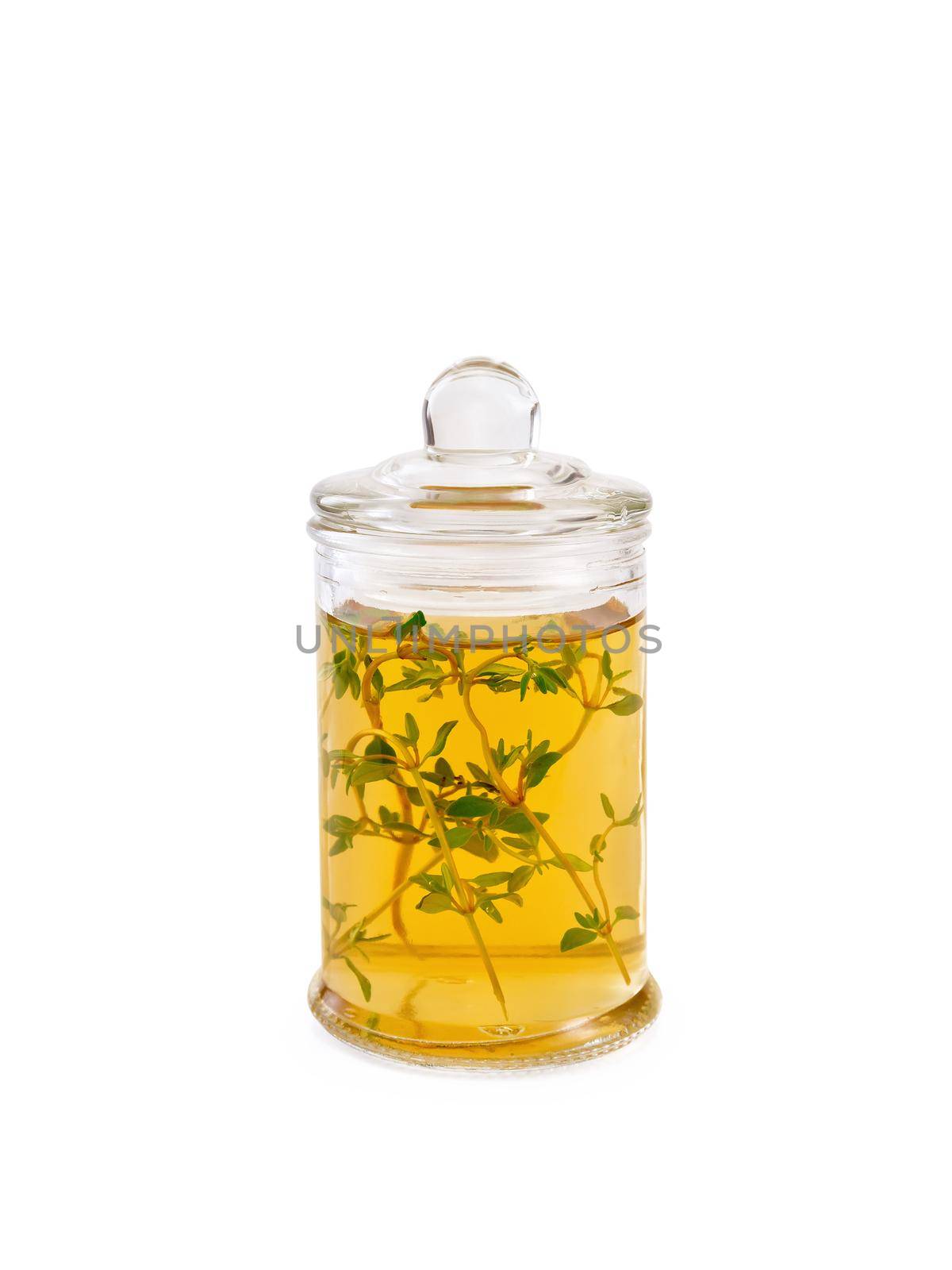 Vegetable oil or vinegar with thyme in a glass jar isolated on white background