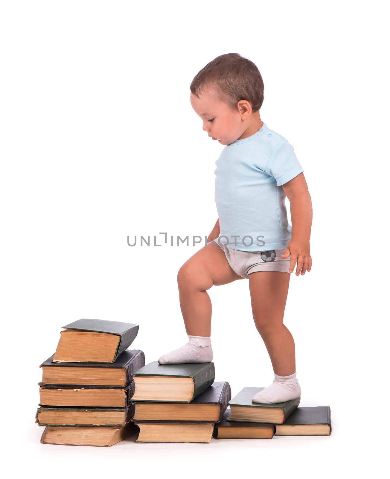 Boy stands on stack of books for educational portrait - isolated over white background by aprilphoto
