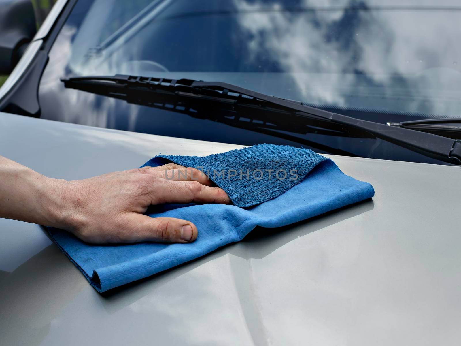 Car detailing and cleaning by hand and microfiber towel. Polishing the car exterior with car shine products or wax result in shine surface.