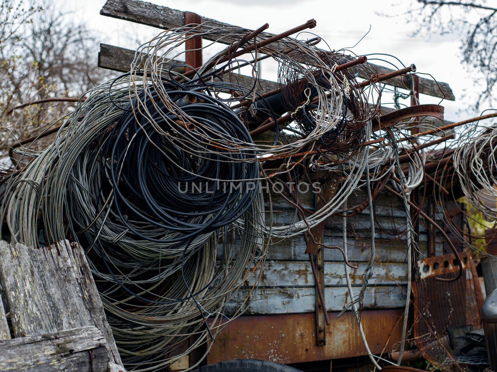 Wires of different kinds are twisted into rings and hang on iron rods.