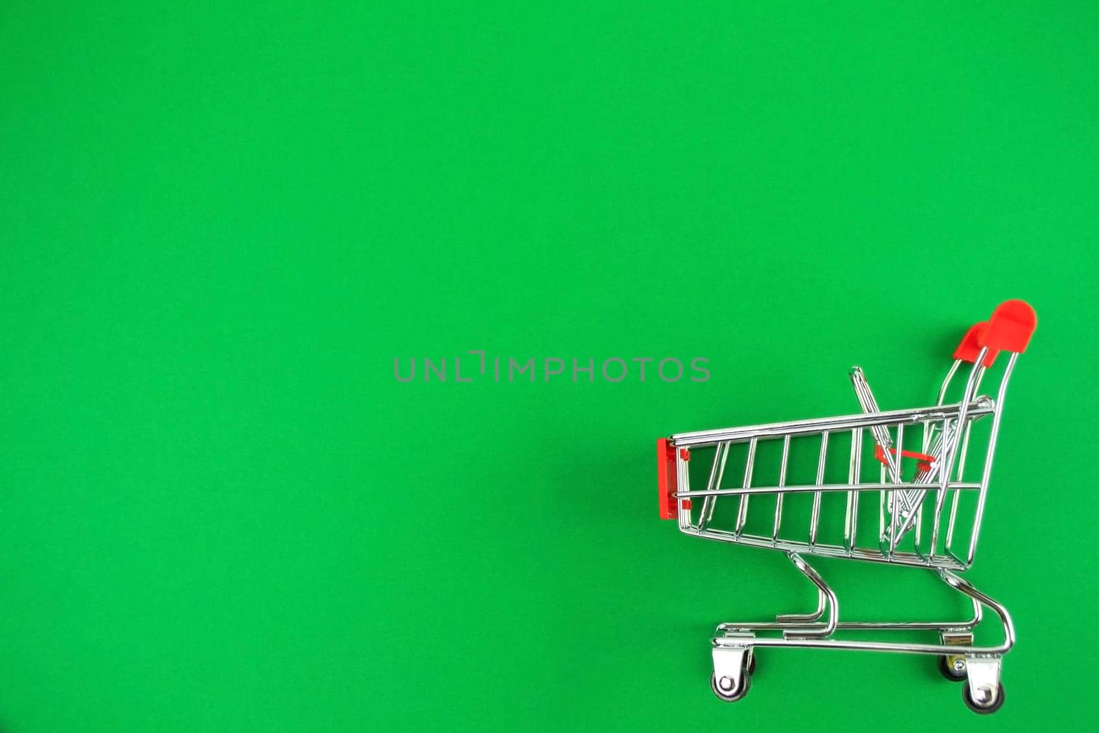 Red Small Shopping Cart Lies Green Background Online Shopping Concept Copy Space