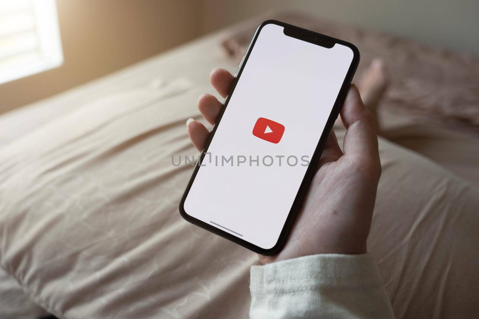 CHIANG MAI, THAILAND - JUNE 7, 2020: Latest generation iPhone X with YouTube logo on the screen by nateemee
