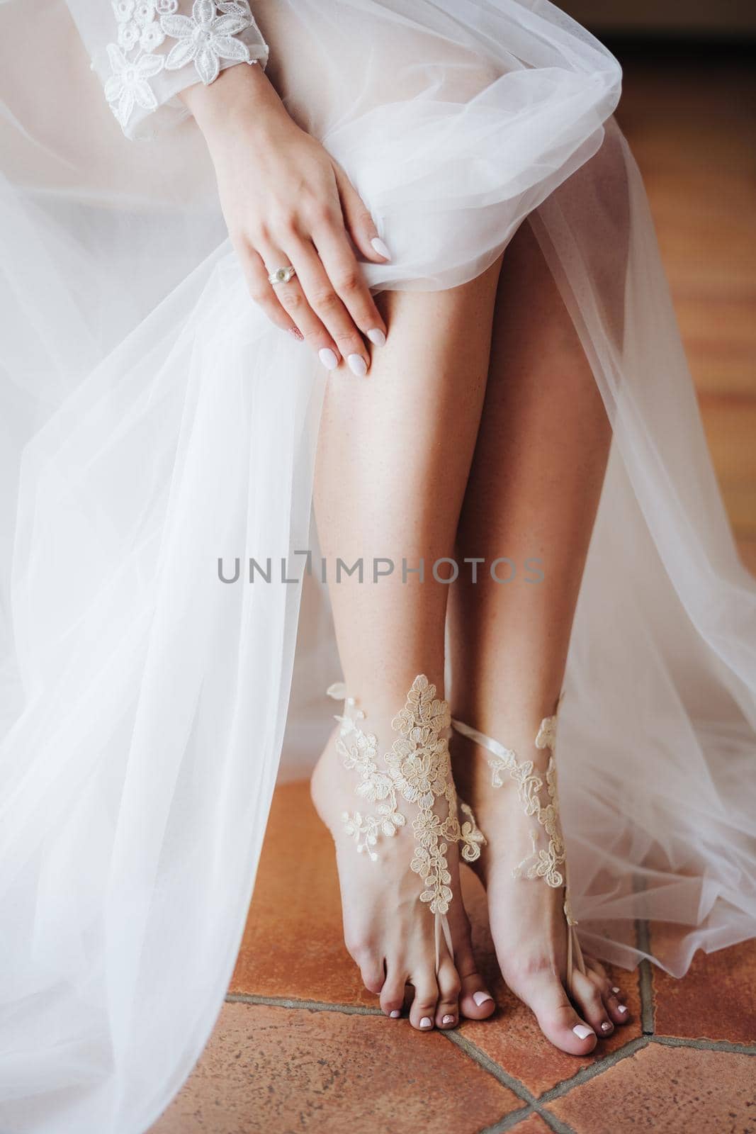 Bride in white wedding dress opened bare feet. High quality photo