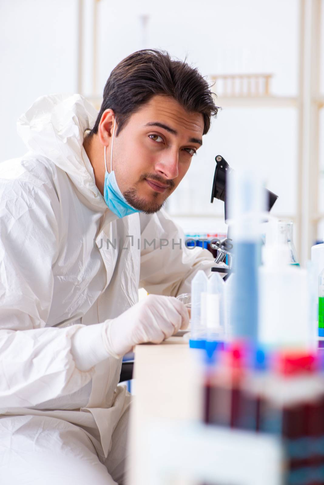 Young chemist student working in lab on chemicals