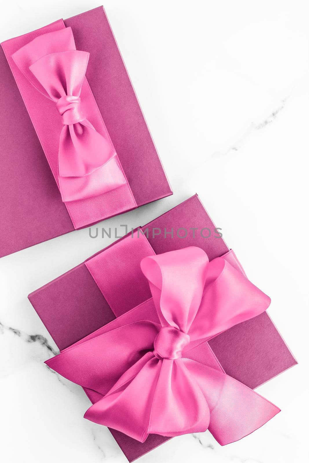 Pink gift box with silk bow on marble background, girl baby shower present and glamour fashion gift for luxury beauty brand, holiday flatlay art design by Anneleven