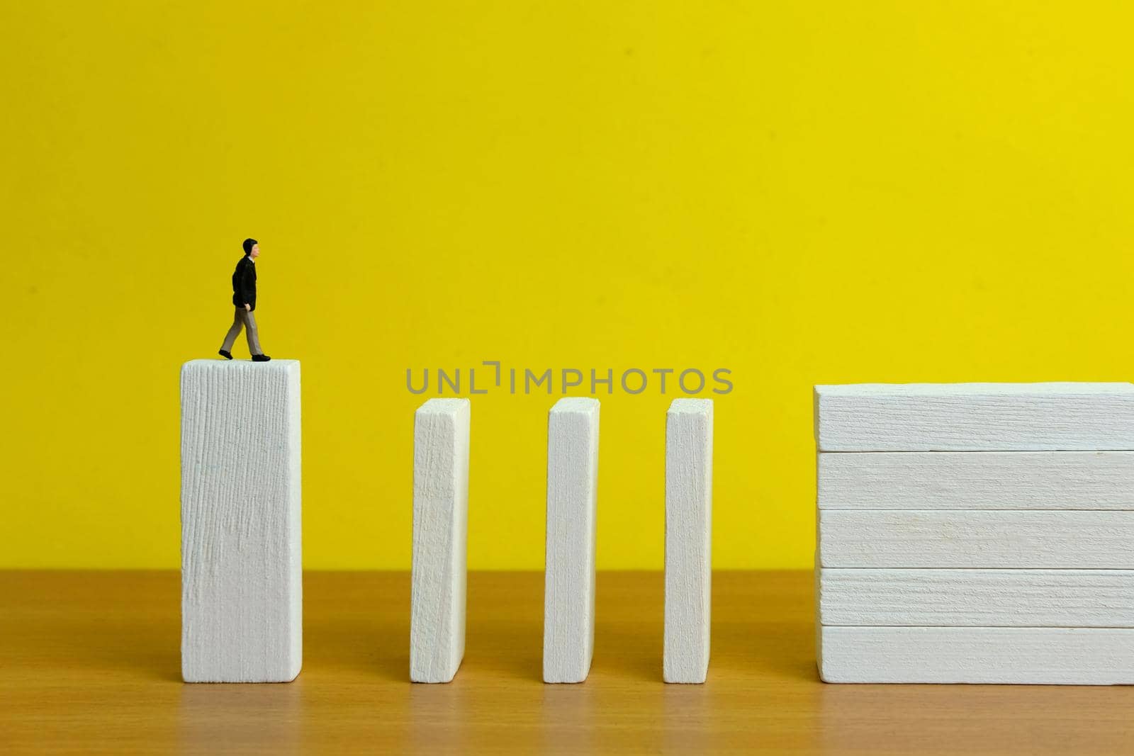 Business strategy conceptual photo - Miniature of businessman stands at the edge of wooden bridge staircase. Image photo