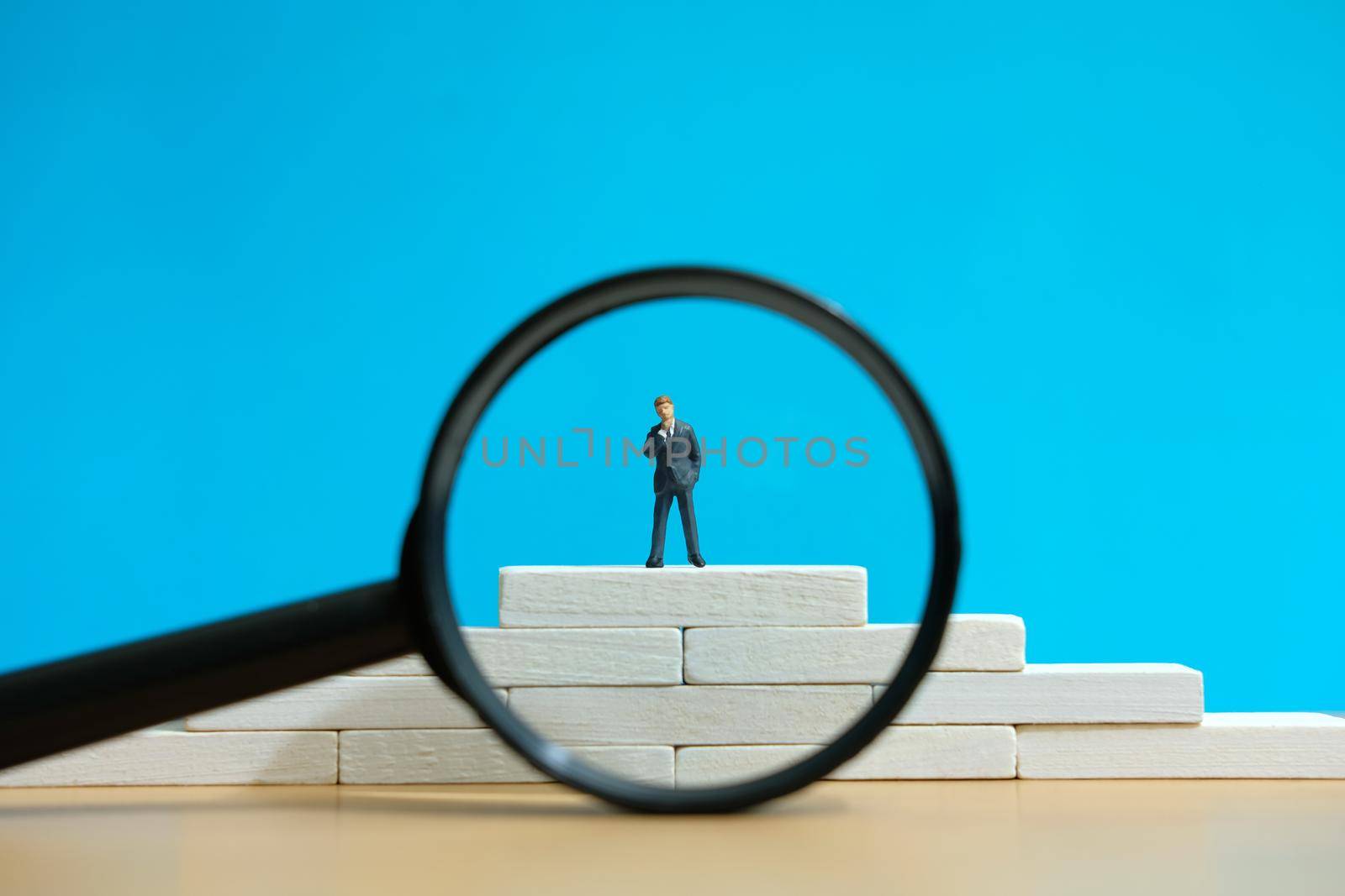 Business strategy conceptual photo - Miniature of businessman stands on a podium. Image photo