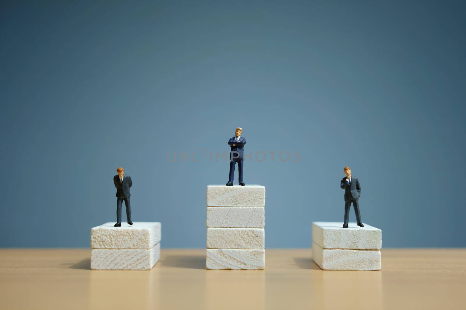 Business strategy conceptual photo - Miniature of businessman stands on a podium. Image photo