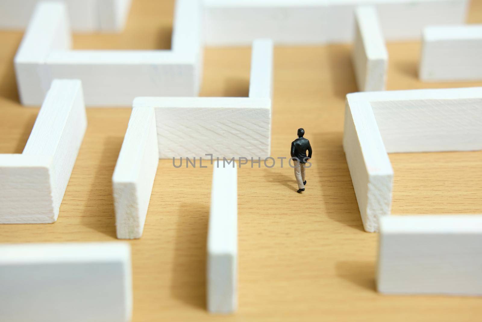 Business strategy conceptual photo - Miniature of businessman looking for solution on a labyrinth maze. Image photo